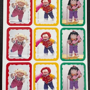 May include: Sheet of Cabbage Patch Kids stickers. Each sticker features a doll in various outfits, including overalls, a letterman jacket, and holding a telephone. The stickers are framed in red, yellow, and green borders. The text "©1992 O.A.A., INC." is visible.