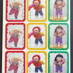 May include: Nine colorful stickers featuring Cabbage Patch Kids dolls. Each sticker features a different doll with a different activity. The dolls are wearing different outfits and have different hair colors. The stickers are all rectangular and have a white background.