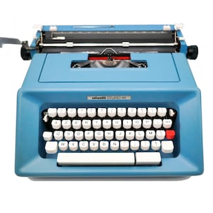Pode incluir: Uma máquina de escrever Olivetti Studio 46 azul com um teclado branco e uma tecla de retorno vermelha.