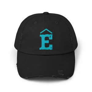 May include: Black distressed baseball cap with a teal letter "E" logo. The logo features a stylized letter "E" with a roof-like design above it. The cap has a curved brim and a distressed, worn look.