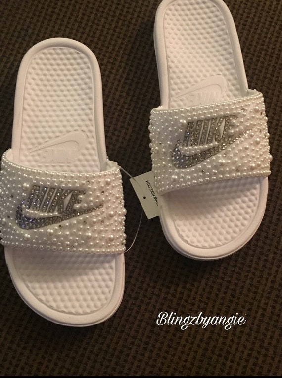 white and silver nike slides