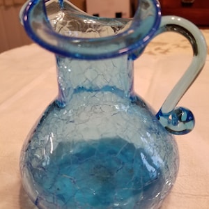 Beau pichet de 5 po. de haut en verre craquelé bleu. Verre soufflé avec bris de pont. Poignée en verre appliqué. Cadeau idéal. Livraison gratuite aux États-Unis.