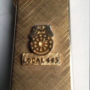 Vintage 14kt Gold Plated Slimline Lighter That is Embossed with the Symbol of the Teamsters  and Local 445