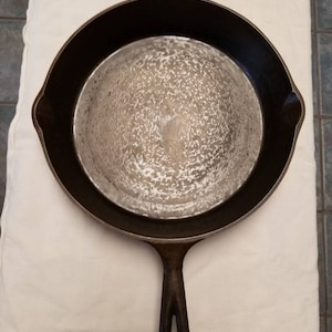 May include: A cast iron skillet with a black handle. The skillet is clean and ready to be used.