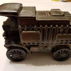 Peut inclure: Un taille-crayon d&eacute;taill&eacute; de style antique en forme de camion vintage. Le taille-crayon de couleur bronze fonc&eacute; pr&eacute;sente des d&eacute;tails complexes, notamment une cabine, une zone de chargement et des roues &agrave; rayons. Le design &eacute;voque la nostalgie et le savoir-faire.