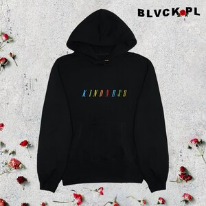 May include: Black hooded sweatshirt with the word "KINDNESS" spelled out in rainbow colors on the front.