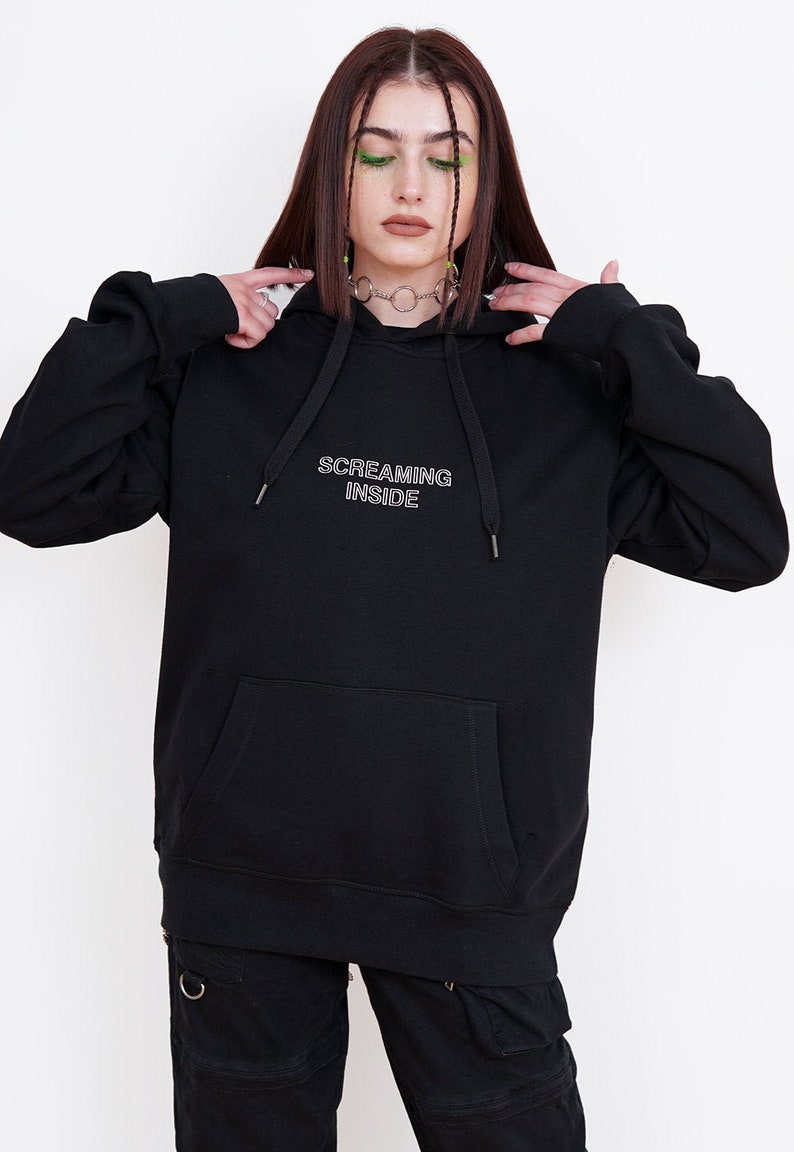 May include: Black hooded sweatshirt with the text "SCREAMING INSIDE" in white outlined lettering.