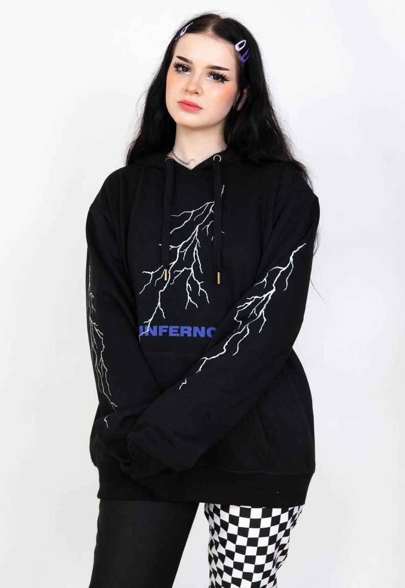 Puede incluir: Sudadera con capucha negra con un gr&aacute;fico de rayo blanco y la palabra "INFERNO" en letras azules.