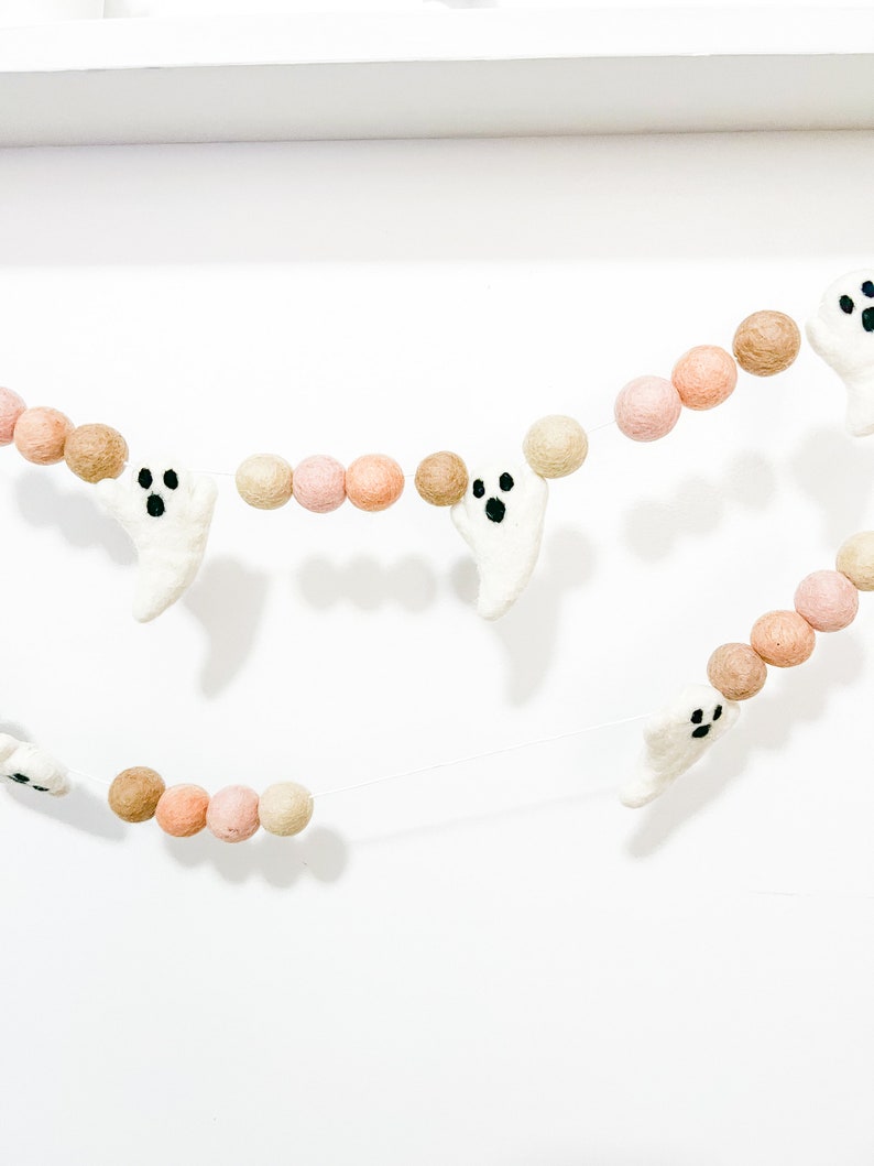 May include: A Halloween garland with white felt ghosts and brown and pink felt balls. The garland is strung on a clear thread.