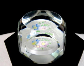 Pisapapeles de 3,8 cm (1 1/2") con diseño floral sobre disco blanco y cristal transparente facetado.