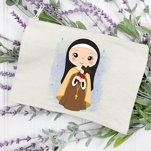 May include: A white canvas zippered pouch with a colorful illustration of a young girl in a brown habit holding a bouquet of flowers and a cross. The background is a light blue watercolor wash with white dots.