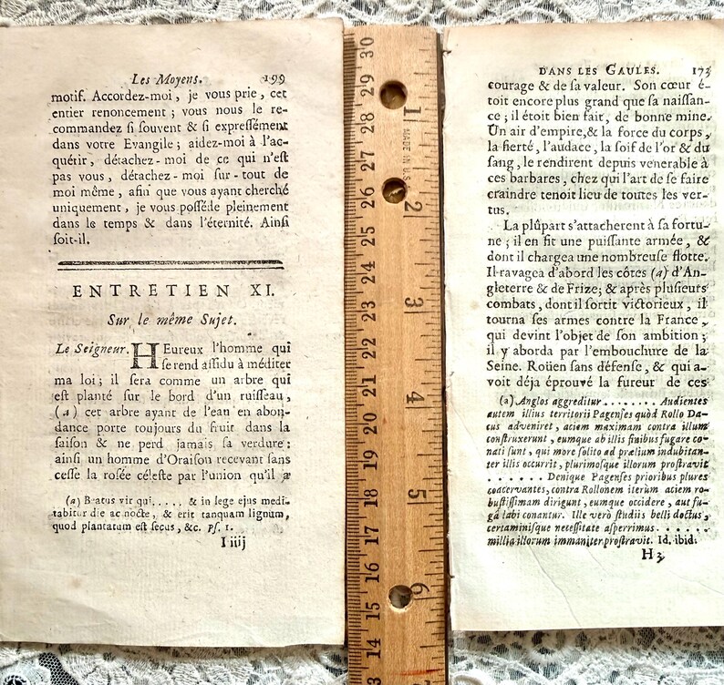 K&ouml;nnte beinhalten: Zwei Seiten aus einem antiken Buch mit franz&ouml;sischem Text, mit einem Lineal zur Ma&szlig;stabsbestimmung. Die Seiten sind gealtert mit sichtbarem Text und einem Lineal, das Messungen in Zentimetern anzeigt. Das Buch scheint ein historisches Dokument zu sein.