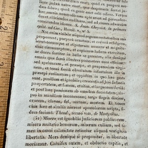 K&ouml;nnte beinhalten: Eine wei&szlig;e Keramik-Tasse mit schwarzem Henkel und dem Text "But First, Coffee" in fetter, schwarzer Schrift. Die Tasse steht vor einem verschwommenen Hintergrund, der eine gem&uuml;tliche Umgebung andeutet.