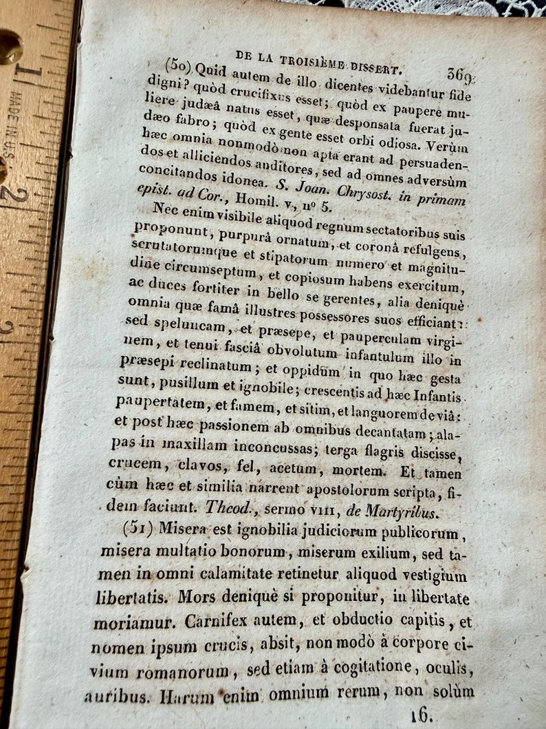 K&ouml;nnte beinhalten: Eine wei&szlig;e Keramik-Tasse mit schwarzem Henkel und dem Text "But First, Coffee" in fetter, schwarzer Schrift. Die Tasse steht vor einem verschwommenen Hintergrund, der eine gem&uuml;tliche Umgebung andeutet.
