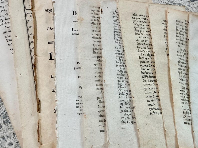 K&ouml;nnte beinhalten: Nahaufnahme von gealterten, strukturierten Papierseiten mit verblasstem schwarzem Text. Die Seiten sind zerrissen und vergilbt, was auf ein antikes Buch oder Manuskript hindeutet. Das Bild weckt ein Gef&uuml;hl von Geschichte und Vintage-&Auml;sthetik.