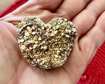 May include: A heart-shaped golden pyrite crystal with a rough, textured surface.