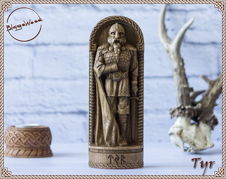 May include: A wooden carving of the Norse god Tyr, standing in a carved wooden frame. The carving is detailed and shows Tyr in full armor, holding a sword. The base of the carving is inscribed with the runes for Tyr.