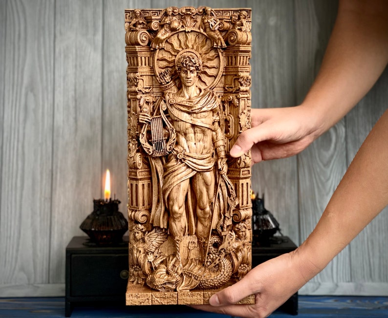 May include: A wooden wall sculpture depicting a male figure with a lyre, surrounded by intricate carvings. The figure is standing in a doorway with a sunburst above. The sculpture is painted in shades of brown and gold.
