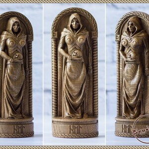 May include: A wooden sculpture of a skeletal figure in a hooded robe, holding a skull in its hands. The sculpture is carved in a detailed style and has a dark brown finish. The sculpture is standing on a base with the inscription "NMM".