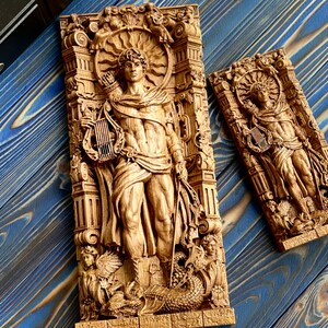 May include: Two wooden wall sculptures depicting a figure holding a lyre. The sculptures are carved in a detailed style and feature intricate designs. The larger sculpture is taller and wider than the smaller one.