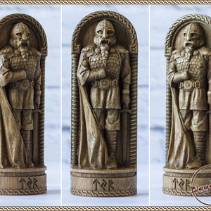 May include: A wooden carving of a Viking warrior with a sword and shield, standing in a carved wooden frame. The carving is detailed and realistic, with intricate details on the warrior's armor and weapons. The base of the carving is inscribed with runes.
