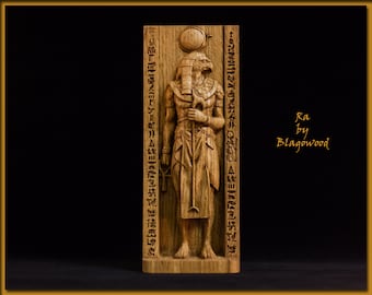 May include: A wooden carving of the Egyptian god Ra, with a hawk head and human body, holding a staff. The carving is surrounded by hieroglyphs and the text "Ra by Blagowood".