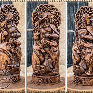 May include: A detailed wooden carving of a figure with a beard, holding a coin, and surrounded by wolves and ravens. The carving has intricate knotwork and is displayed on a wooden base. The wood has a warm, brown tone.