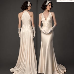 May include: A floor-length cream-colored satin gown featuring a deep V-neckline, a halter-style back, and a fitted bodice. The garment is paired with elbow-length white gloves, a pearl necklace, and a floral hair accessory.