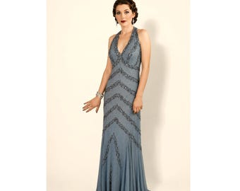 May include: A floor-length slate blue sleeveless gown featuring a deep V-neckline and a halter-style bodice. The dress is adorned with intricate dark grey beadwork arranged in a chevron pattern throughout the front, ending in a flared hem.