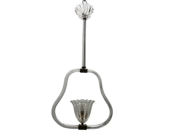 Könnte beinhalten: Eine klare Glaspendelleuchte mit birnenförmigem Design. Die Leuchte hat eine einzelne Glühbirne und eine dekorative Glasoberseite.