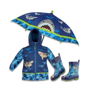 May include: A blue raincoat with a shark print, a blue umbrella with a shark print, and blue rain boots with a shark print.