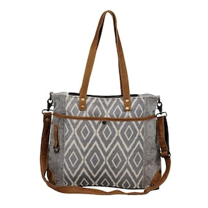 May include: A gray and white geometric patterned tote bag with brown leather straps and a detachable shoulder strap.