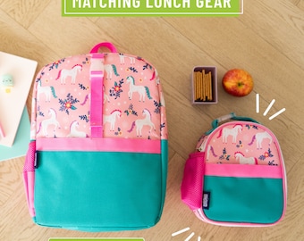 May include: A pink and teal lunch bag with a unicorn print. The lunch bag has a zipper closure and a mesh pocket on the side. The lunch bag is part of a matching set with a larger backpack.