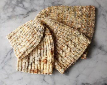 May include: Three knitted hats in a beige and yellow color scheme with a cable knit pattern.
