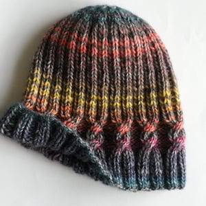 May include: A gray, black, and orange striped knitted beanie hat with a folded brim.