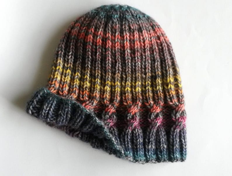 May include: A gray, black, and orange striped knitted beanie hat with a folded brim.