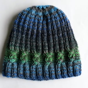 May include: A blue, green, and gray knitted hat with a cable knit pattern.
