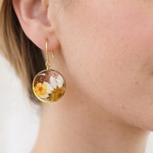 Small dangling hoop earrings in steel, real daisy flowers, opal resin, orange flowers. Real pressed dried flower jewelry.