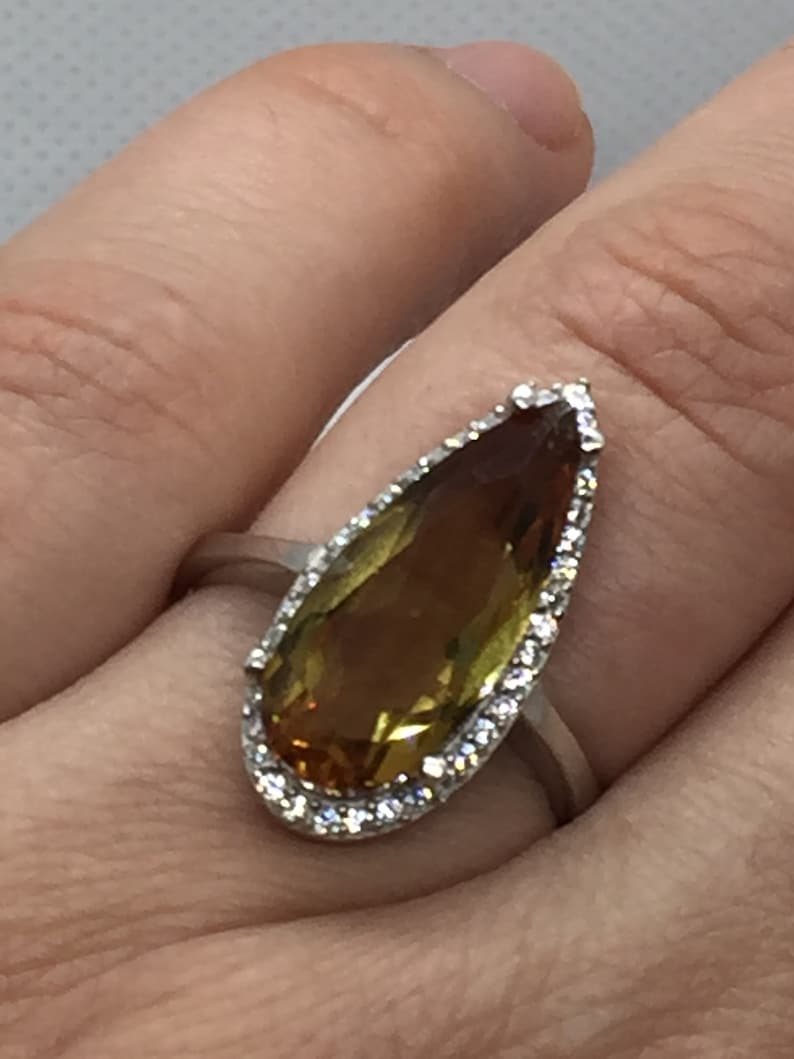A silver ring with Natural Turkish Color Change Diaspore and a lot of small zirconia stones around it 925 Sterling Silver rhodium plated