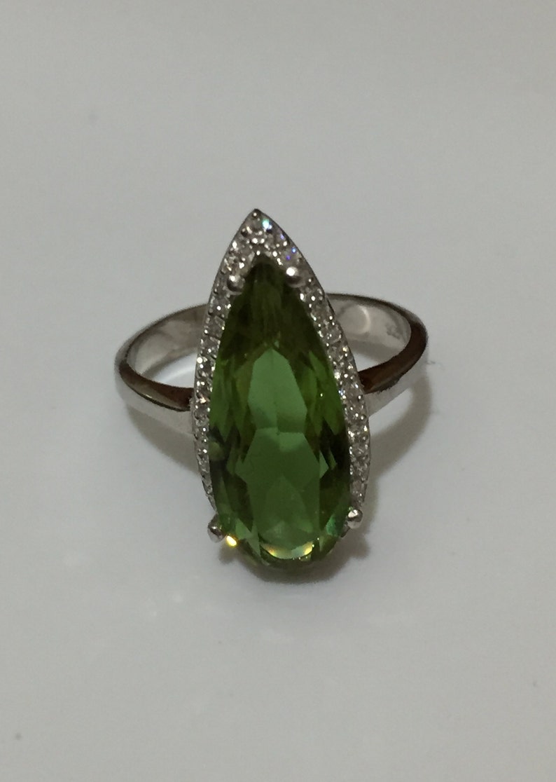 A silver ring with Natural Turkish Color Change Diaspore and a lot of small zirconia stones around it 925 Sterling Silver rhodium plated