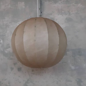 May include: A white, round, hanging lampshade with a pleated design.