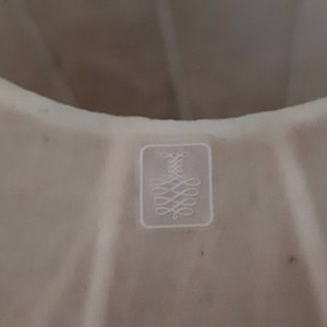 May include: White cake pan with a fluted design and a small embossed logo on the bottom.