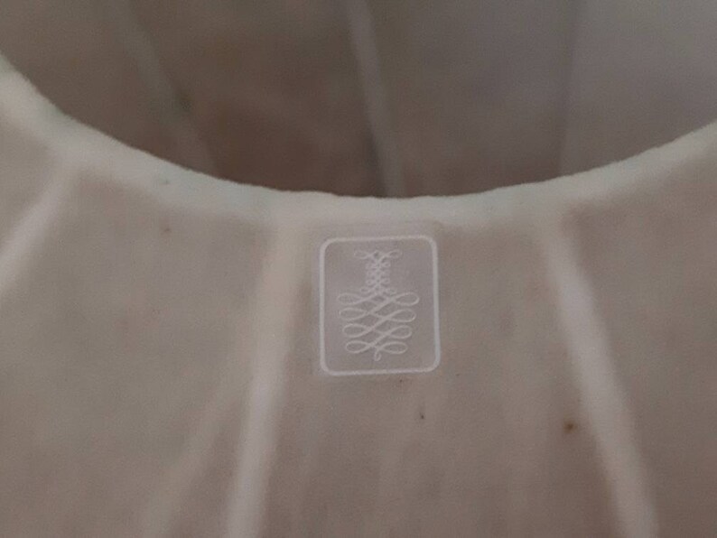 May include: White cake pan with a fluted design and a small embossed logo on the bottom.