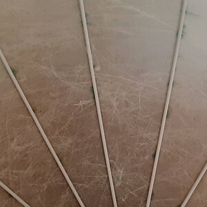 May include: Close-up of a beige ceiling with white, evenly spaced, vertical lines.