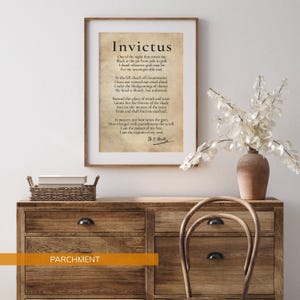 a framed quote of the Roman poet Virgil, "Invictus," displayed on a wooden dresser. The quote is accompanied by a vase of white flowers and a wicker basket.
