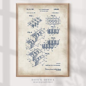May include: A framed print of a vintage toy building brick patent illustration. The blueprint-style drawing, in blue ink, shows various views of the brick, including top, side, and cross-section details. The print includes the inventor's name and the date of the patent.