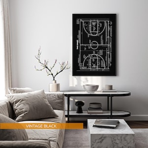 Op de afbeelding: Een zwart-wit afdruk van een basketbalveld diagram. De afdruk toont de lay-out van het veld met lijnen, cirkels en tekst. De woorden "THE COURT" zijn verticaal afgedrukt. De tekst "VINTAGE BLACK" is op een gouden balk afgedrukt.