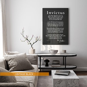 a living room with a gray sofa, a black coffee table, and a framed quote on the wall.