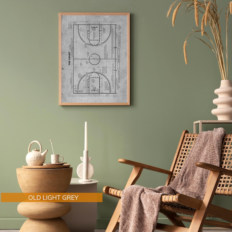 Op de afbeelding: Een ingelijste print van een basketbalveld diagram in lichtgrijs. Het gedetailleerde diagram bevat lijnen, cirkels en tekst, tegen een achtergrond met textuur. De lijst is gemaakt van lichtbruin hout. De print is getiteld "THE COURT".