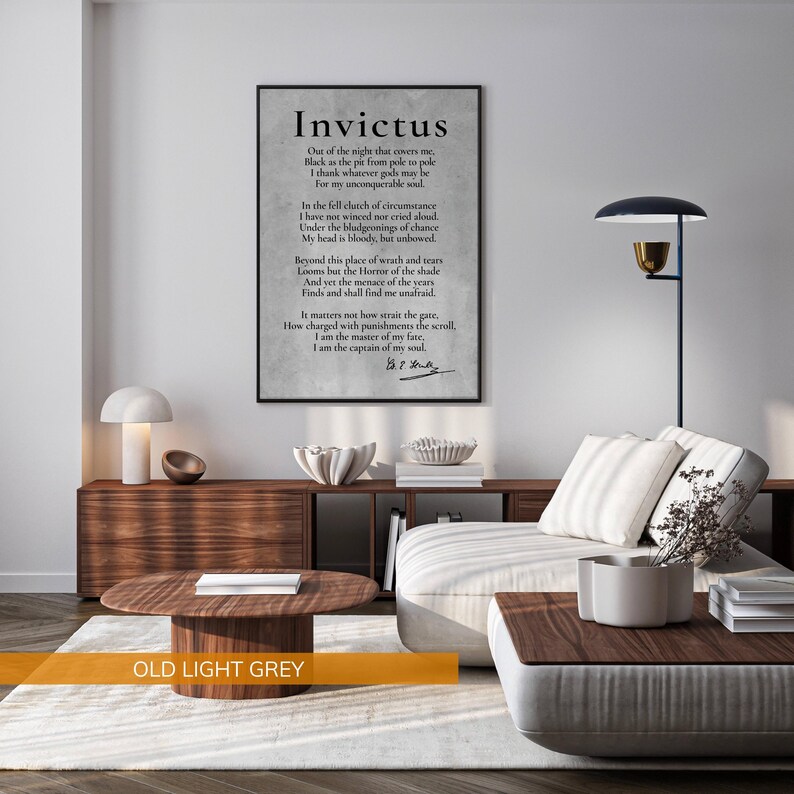 a modern living room with a large framed quote of the poem "Invictus" by William Shakespeare displayed on the wall. The quote is in black text and is surrounded by a wooden frame. The living room has a white sofa, a wooden coffee table, and a lamp on a side table. The overall color scheme of the room is a combination of white and brown, with a touch of black.